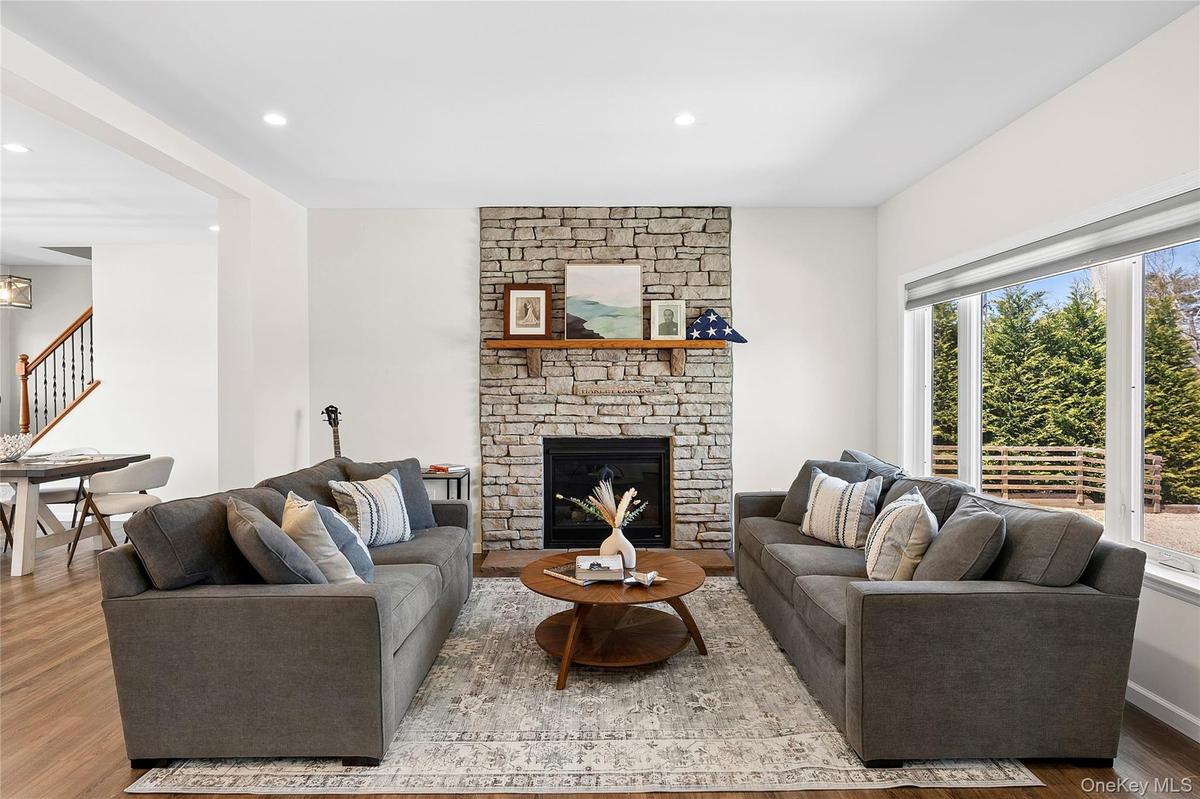 Living room featuring wood finished floors, a fireplace, and recessed lighting