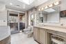 Master Bathroom Suite with a bidet, vanity, tile walls, a skylight, and light tile patterned floors