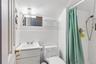 Attic Full bathroom with vanity, tile walls, a stall shower, and wainscoting