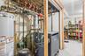 Utility room featuring gas water heater and a heating unit