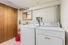 Laundry room with independent washer and dryer and light tile patterned flooring