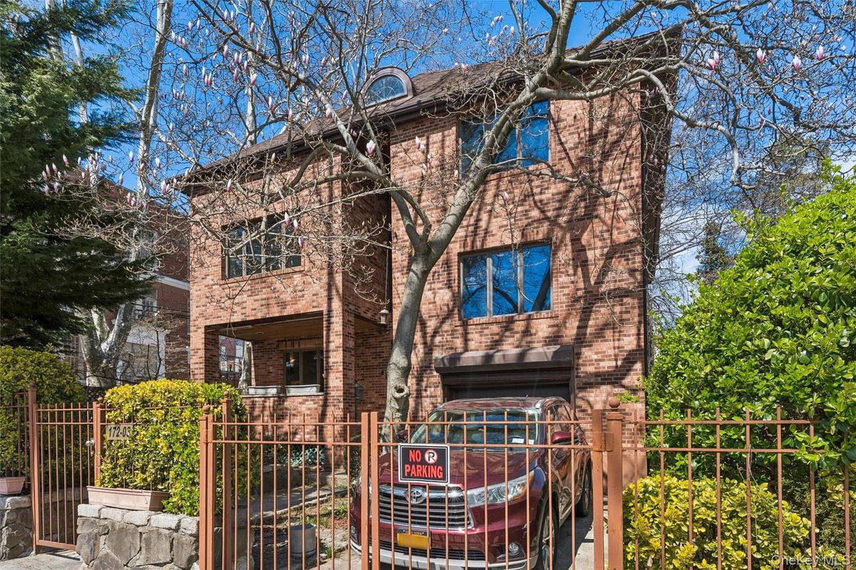 View of front of house with a fenced front yard, brick siding, and a gate