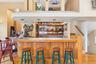 Indoor wet bar featuring light wood-type flooring and open shelves