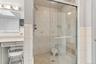 Master Bathroom Suite featuring a shower stall, tile walls, and vanity