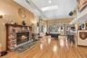 Playroom with a skylight, a fireplace, light wood-style flooring, billiards, and a high ceiling