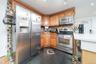 Kitchen with stainless steel appliances, granite tiled floors, decorative backsplash, wood finish cabinetry, and recessed lighting