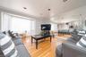 Living room featuring light wood finished floors, plenty of natural light, and crown molding