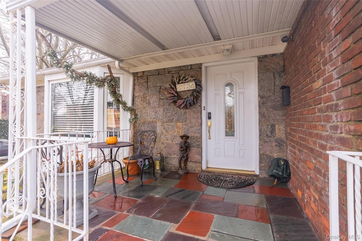 Entrance to property with stone siding and covered porch