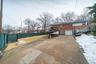 View of side of property featuring concrete driveway, brick siding, an attached garage, and roof mounted solar panels