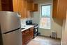 Kitchen featuring freestanding refrigerator, gas range, a healthy amount of sunlight, and radiator