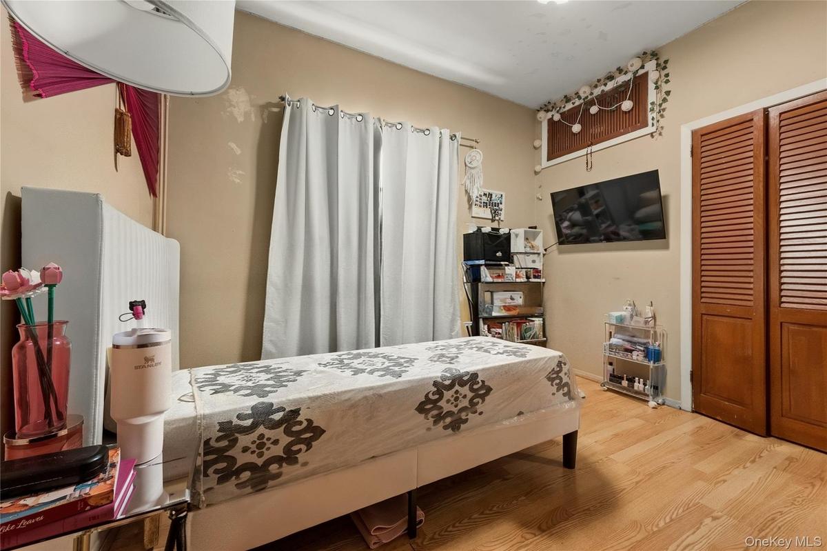Bedroom featuring wood finished floors and a closet