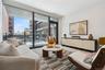 Living area with healthy amount of natural light, a wall of windows, and wood finished floors