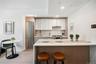 Kitchen with freestanding refrigerator, a breakfast bar area, a sink, white cabinetry, and light wood-style floors
