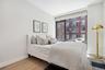 Bedroom featuring baseboards, wood finished floors, and floor to ceiling windows