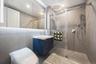 Bathroom featuring tiled shower and vanity