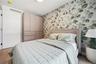 Bedroom with wallpapered walls and wood finished floors