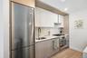 Kitchen with appliances with stainless steel finishes, a sink, light countertops, light wood-style flooring, and white cabinetry