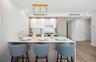 Kitchen with a breakfast bar, light countertops, a peninsula, modern cabinets, and recessed lighting