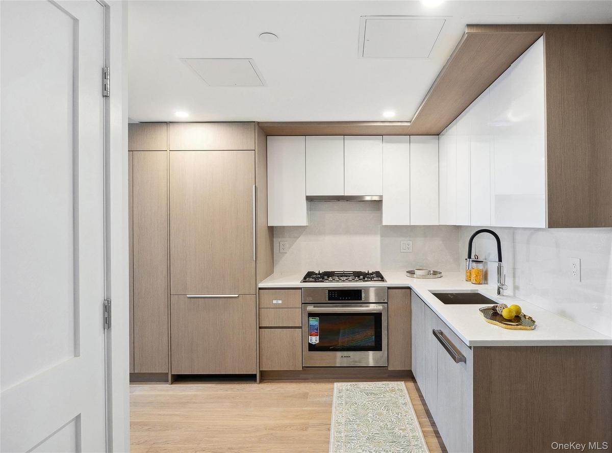 Kitchen with appliances with stainless steel finishes, a sink, modern cabinets, and recessed lighting
