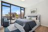 Bedroom featuring a view of city, wood finished floors, baseboards, expansive windows, and access to outside