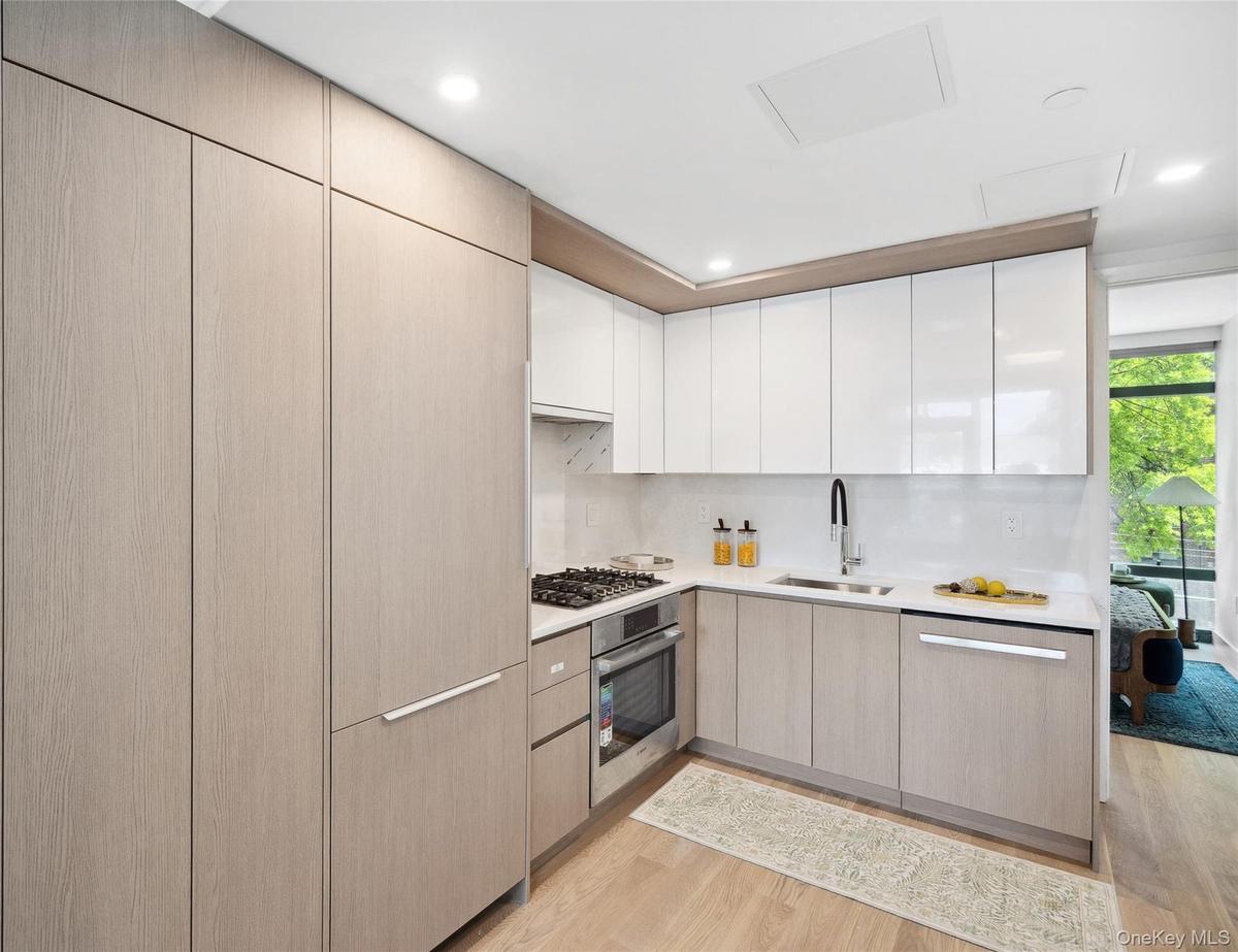 Kitchen featuring a sink, stainless steel appliances, light wood-style floors, light countertops, and recessed lighting