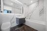 Full bathroom featuring shower / bath combination, marble tiled flooring, vanity, toilet, and tile walls