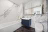 Bathroom featuring tile walls, toilet, shower / bath combination, vanity, and marble finish floors