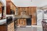 The kitchen is thoughtfully appointed with custom-made cabinetry, a convenient pull-out pots and pans shelves and sleek granite countertops and floori