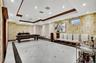 Common area featuring wallpapered walls, crown molding, a tray ceiling, and recessed lighting
