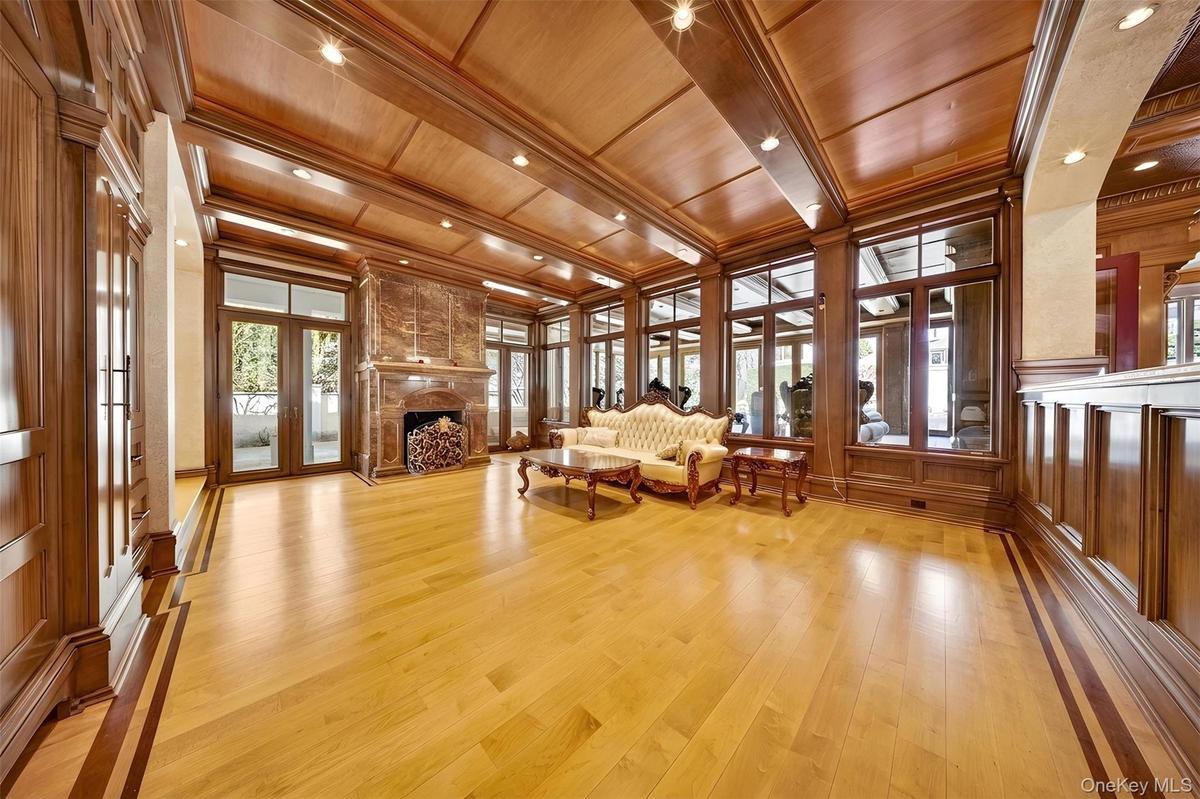 Living area featuring wooden ceiling, french doors, light wood-style floors, a fireplace, and a decorative wall