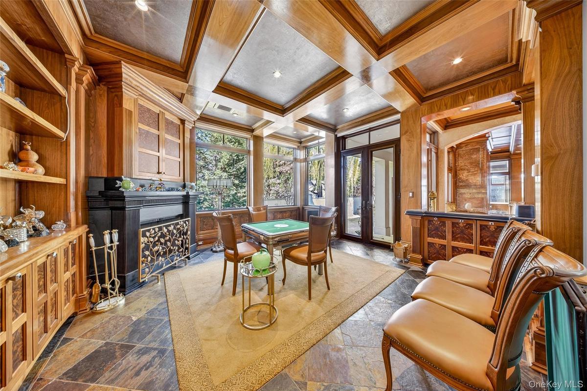 Home office featuring coffered ceiling, a fireplace, healthy amount of natural light, ornamental molding, and stone finish floors