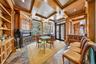 Home office featuring coffered ceiling, a fireplace, healthy amount of natural light, ornamental molding, and stone finish floors