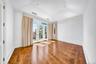 Spare room featuring wallpapered walls, wood finished floors, vaulted ceiling, and recessed lighting