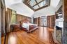 Bedroom with arched walkways, access to exterior, light wood-style flooring, and a fireplace