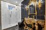 Bathroom featuring tile walls, a marble finish shower, and vanity