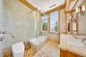 Full bath featuring double vanity, tiled shower / bath, and tile walls