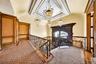 Hallway with hanging lights, a tray ceiling, crown molding, an upstairs landing, and carpet
