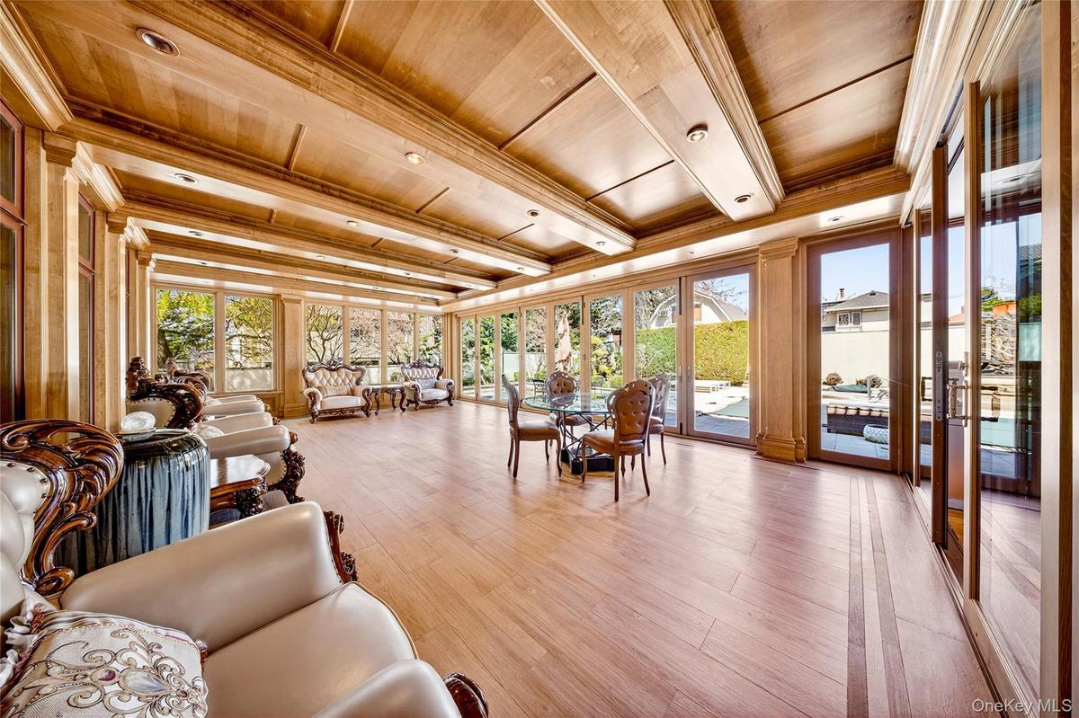 Sunroom with wooden ceiling, wood finished floors, french doors, and ornamental molding