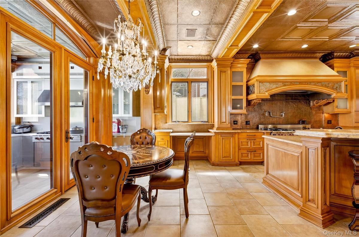 Dining space with hanging lights, an ornate ceiling, light tile patterned floors, and crown molding