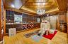 Wine room featuring a chandelier, light wood-style flooring, wood walls, and a wooden tray ceiling