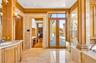 Doorway featuring french doors, crown molding, and tile walls