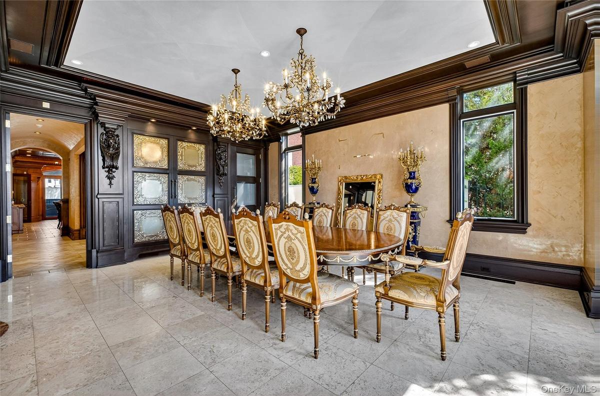 Dining space featuring arched walkways, suspended lighting, and ornamental molding