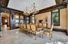 Dining space featuring arched walkways, suspended lighting, and ornamental molding