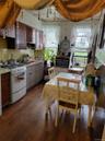 Kitchen with sink, dark wood-type flooring, range, dark brown cabinets, and tasteful backsplash