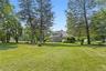 View of grassy yard featuring view of scattered trees