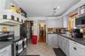 Kitchen featuring, dark countertops, backsplash, light tile patterned flooring, and healthy amount of natural light