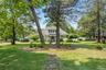 View of front of home with a front lawn and a shingled roof