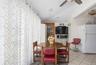 Dining room featuring vaulted ceiling, radiator, light tile patterned flooring, and ceiling fan