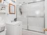 Bathroom with vanity and bath / shower combo with glass door