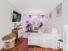 Apt 1 - Living room with a chandelier, wood finished floors, and a wall mounted AC